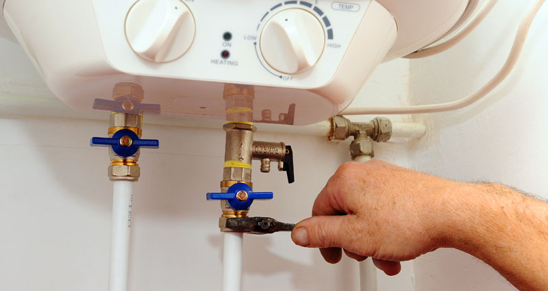 Close up of man turning off water heater