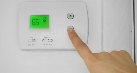 hand sets thermostat to 66