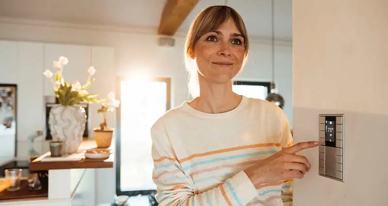 Woman checking settings on the furnace