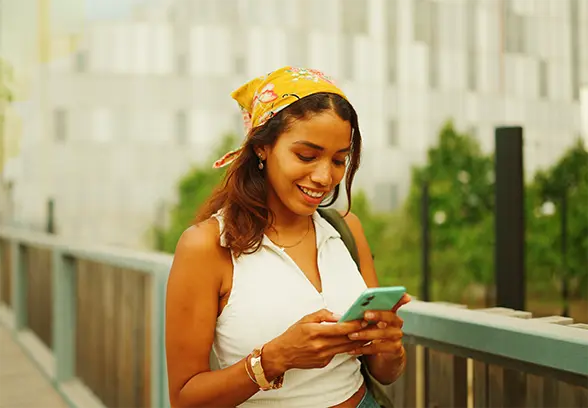 Young african american woman sitting on ground with dog on couch looking at laptop