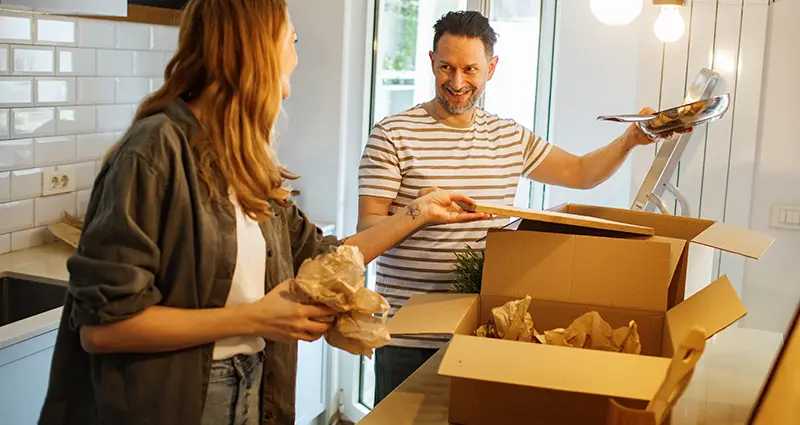 Couple packing kitchen items in boxes