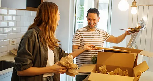 Couple packing kitchen items in boxes