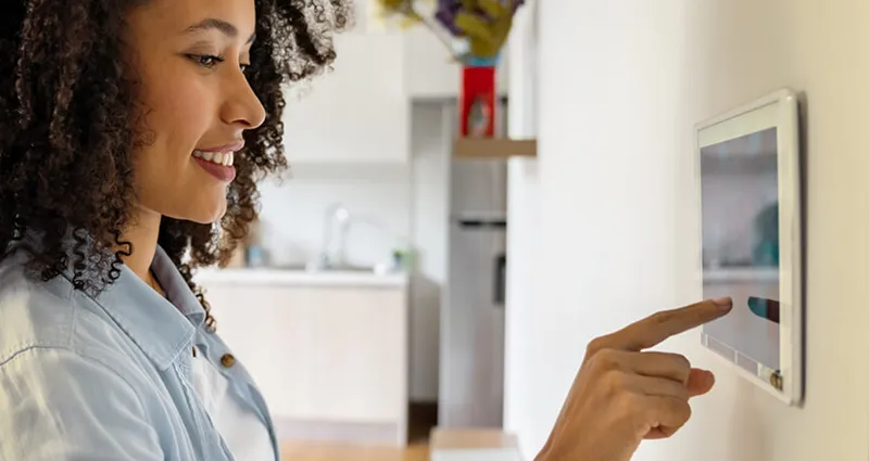 Lady adjusting smart thermostat