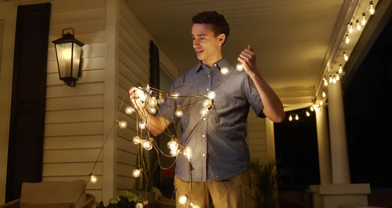 Man hanging lights on porch