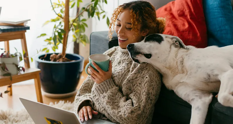 Woman sitting on the floor with her dog and laptop