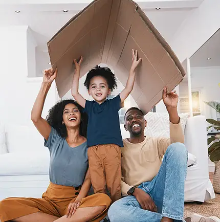 family having fun while moving making a cardboard house