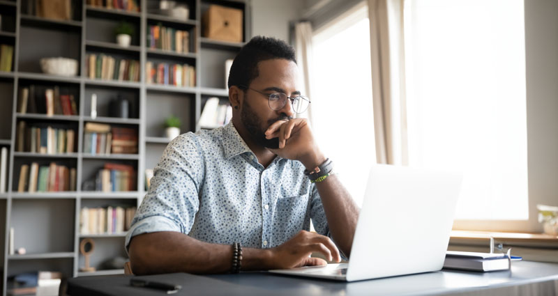 Man looking at laptop on desk