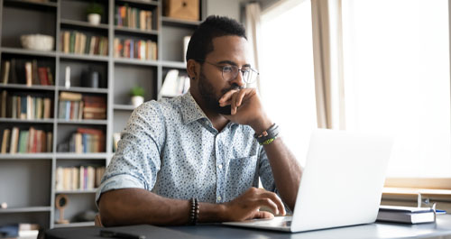 Man looking at laptop on desk