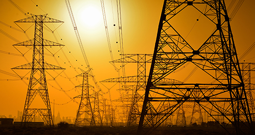 photo of a power grid with sun shining 