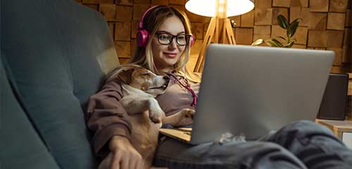 Woman on couch with pet and laptop