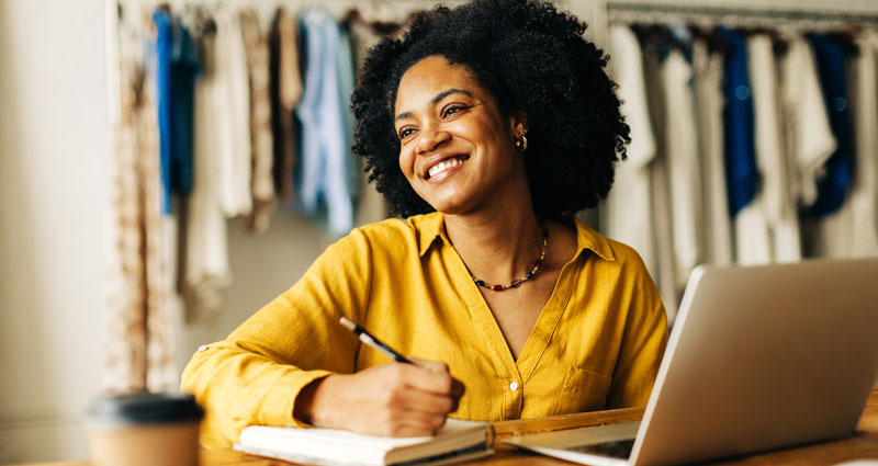 Woman enjoying coffee in front of electric heater with her cat