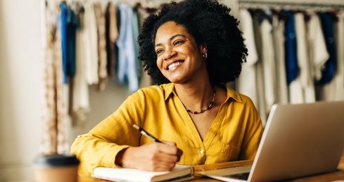 Woman enjoying coffee in front of electric heater with her cat