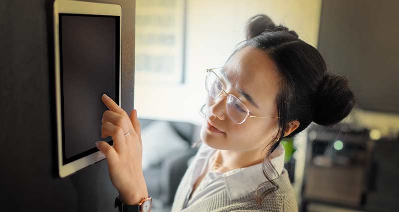 Photograph of a woman and her cat sitting in front of a portable electric heater 