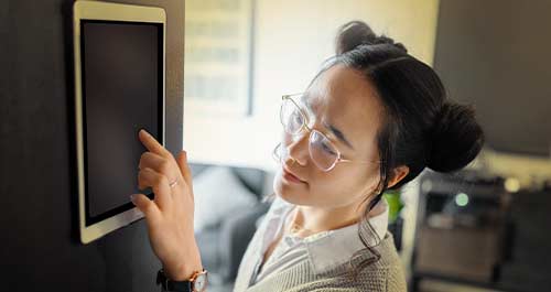 Photograph of a woman and her cat sitting in front of a portable electric heater 