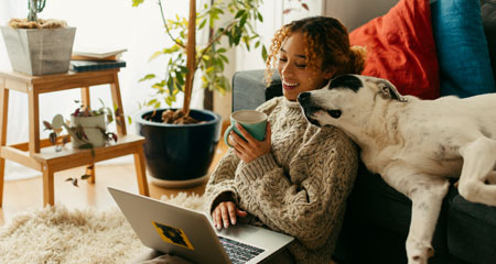 Photograph of a woman and her cat sitting in front of a portable electric heater 