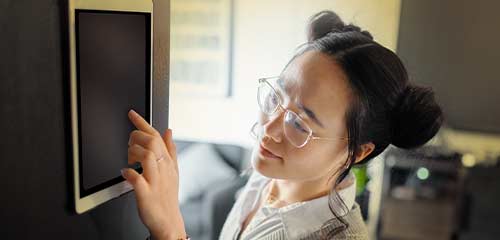 Photograph of a woman and her cat sitting in front of a portable electric heater 