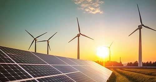 House rooftop with solar panels and wind turbines in the background