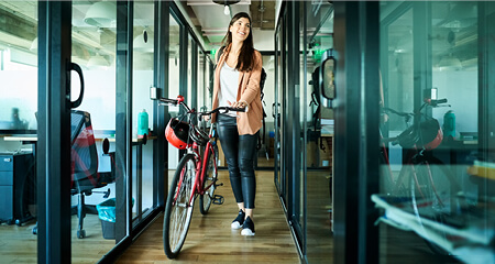 Businesswoman arriving to work on bike