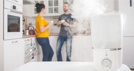 Couple standing in background while humidifier runs on the kitchen counter