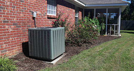 Air conditioner system next to a home outdoors
