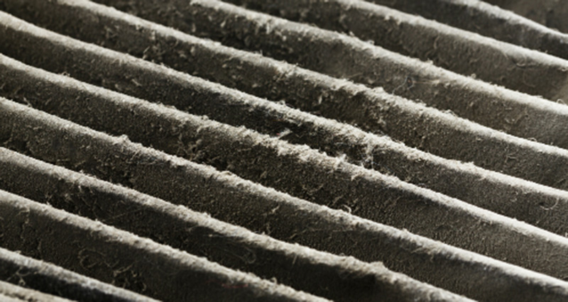 Close-up photo of a dirty air filter covered in dust 