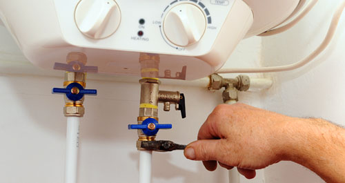 Close up of man turning off water heater