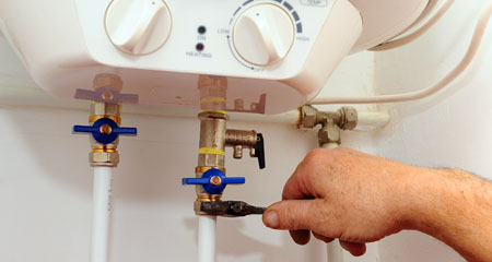 Close up of man turning off water heater