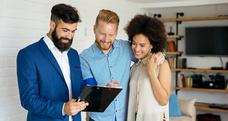 Young couple standing with agent buying a home