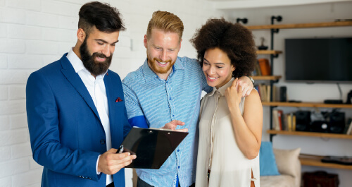 Young couple standing with agent buying a home