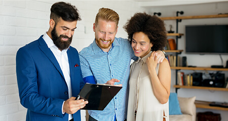 Young couple standing with agent buying a home