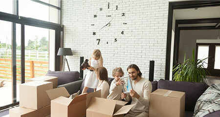 Kids unpacking boxes with their parents in modern living room