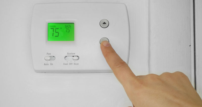 hand sets thermostat to 66