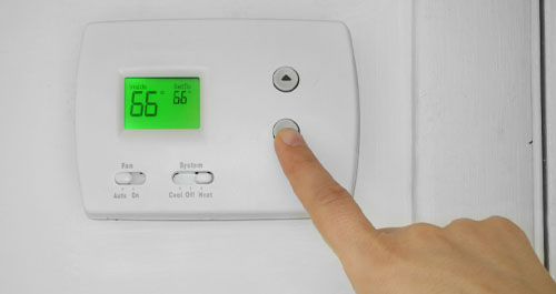 hand sets thermostat to 66