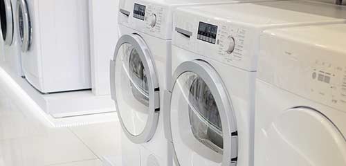 Lots of laundry appliances in a row