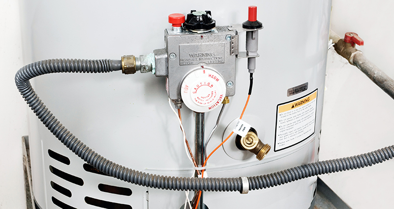 Photograph of a hot water heater's label, coils, and thermostat