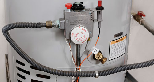 Photograph of a hot water heater's label, coils, and thermostat