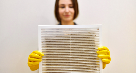 Woman holding dusty air filter