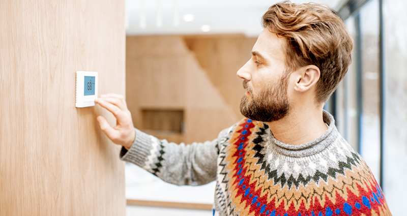 Man adjusting thermostat