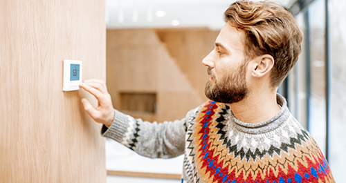 Man adjusting thermostat