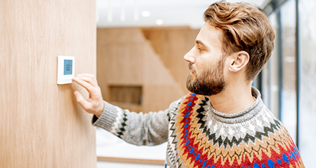 Man adjusting thermostat