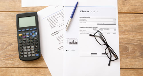 Electric bill and calculator on table