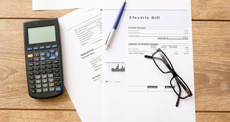 Electric bill and calculator on table