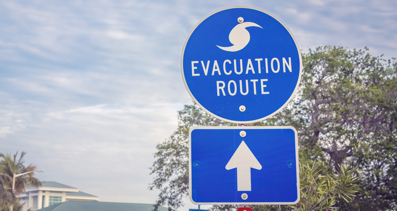 Hurricane evacuation route road sign on blue with arrow