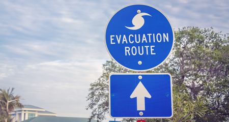 Hurricane evacuation route road sign on blue with arrow