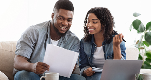 Couple bill budgeting at home on the couch